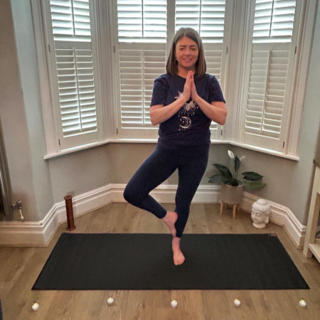 Portrait of Sharon Curran practising Tree Pose in a peaceful studio, reflecting balance, mindfulness and wellbeing.