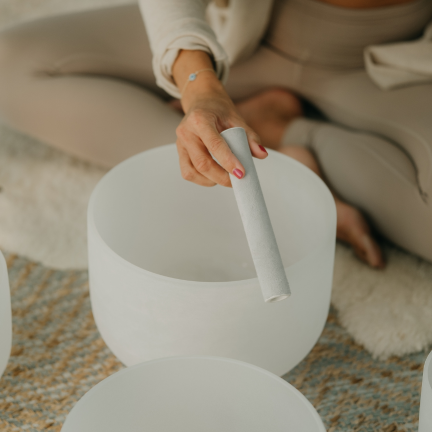 Crystal singing bowls arranged for a restorative sound bath promoting deep relaxation and nervous system restoration.